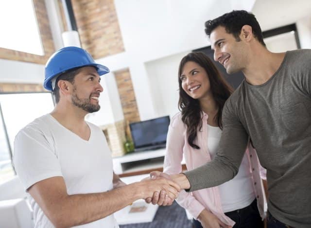 couple shaking hands with a bathroom remodeling contractor