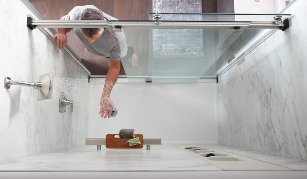 man inspecting KOHLER LuxStone shower